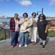Photo of leadership: four adults and one baby standing together outside smiling