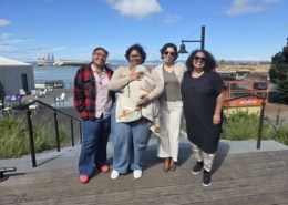 Photo of leadership: four adults and one baby standing together outside smiling