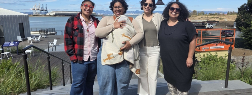 Photo of leadership: four adults and one baby standing together outside smiling